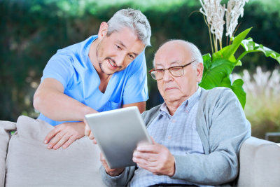 caregiver and senior man reading