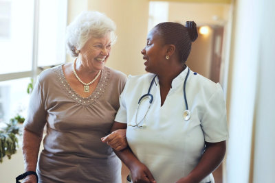 caregiver and senior woman talking while walking